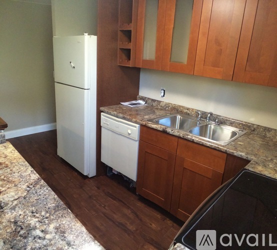 A kitchen with a white fridge and a granite counter top.