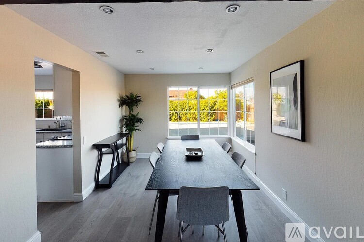A dining room with a long table and chairs is available for rent.