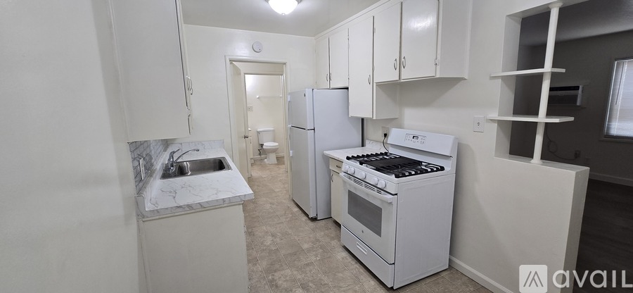 A small kitchen with a white fridge and stove.