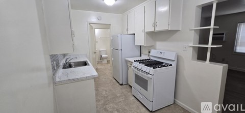 A small kitchen with a white fridge and stove.