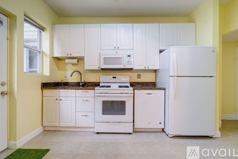 A kitchen with white appliances and cabinets.