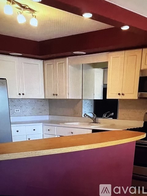 A kitchen with a purple counter and wooden cabinets.