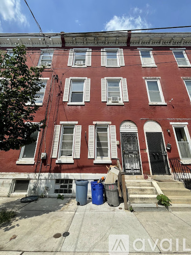 A red building with white trim and a black door.