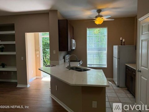 A kitchen with a white countertop and a ceiling fan.