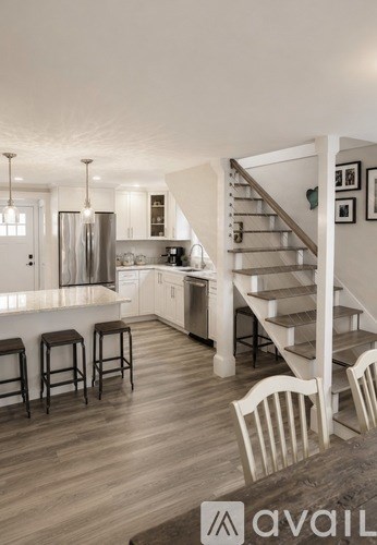 A modern kitchen with a staircase leading to the upper floor.