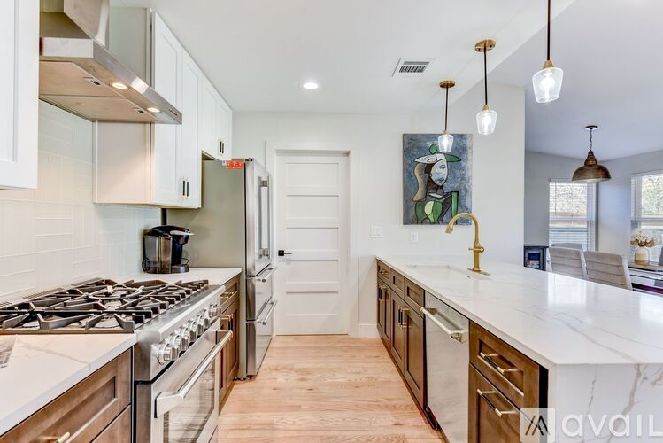 A kitchen with a white counter top and stainless steel appliances.