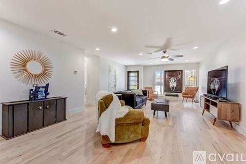 A living room with a yellow chair and a wooden floor.