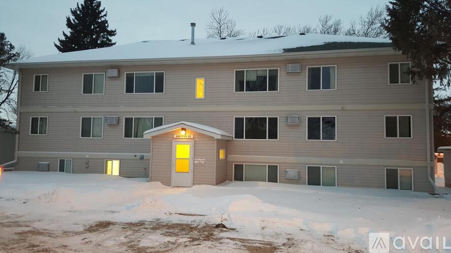 A building with a yellow door in the middle of a snowy area.