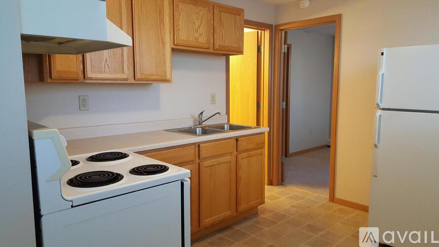 A kitchen with wooden cabinets and a white stove top oven.
