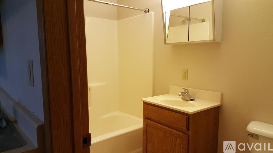 A bathroom with a sink, mirror, and bathtub.