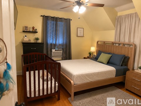 A bedroom with a bed, dresser, and a ceiling fan.