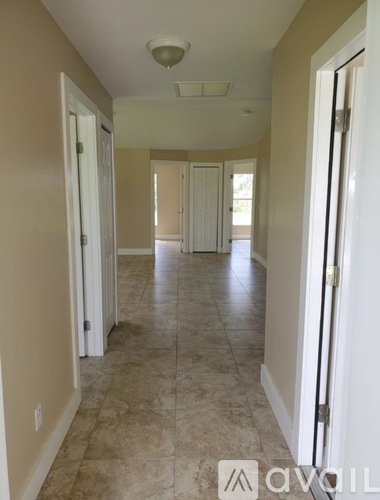 A hallway with tiled floors and white doors.