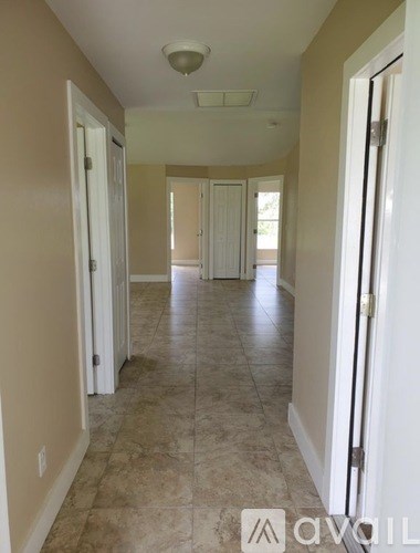 A hallway with tiled floors and white doors.