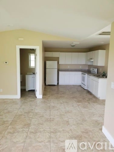 A kitchen with white appliances and cabinets.