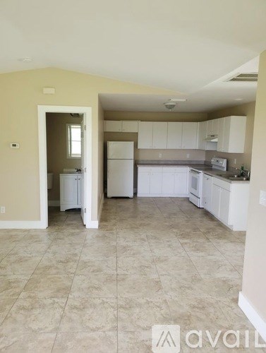 A kitchen with white appliances and cabinets.