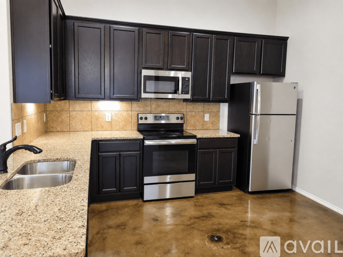 A kitchen with black cabinets and stainless steel appliances.