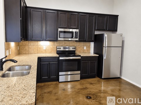 A kitchen with black cabinets and stainless steel appliances.