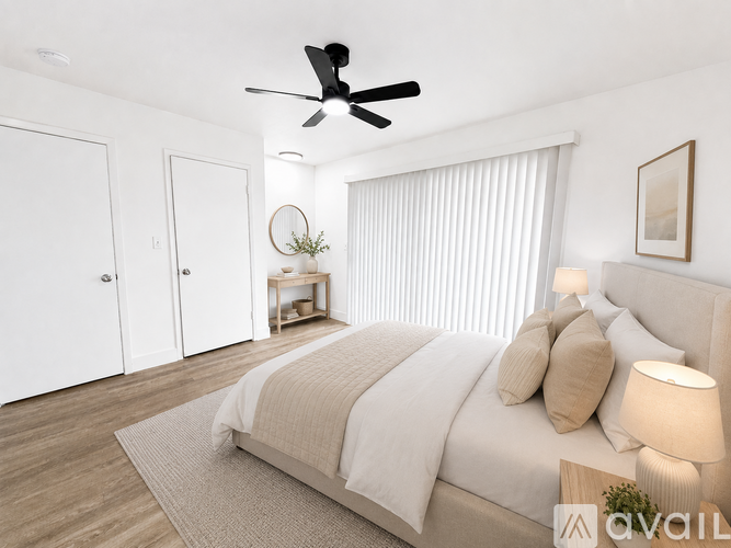 A bedroom with a large bed and a ceiling fan.