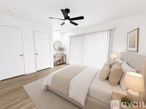 A bedroom with a large bed and a ceiling fan.