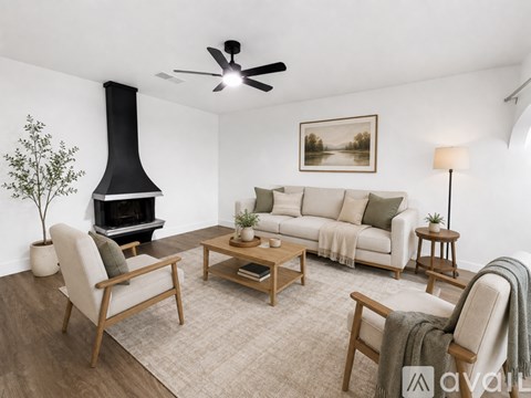 A living room with a fireplace, sofa, and chairs.