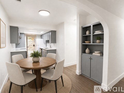 A modern dining room with a round table and chairs.