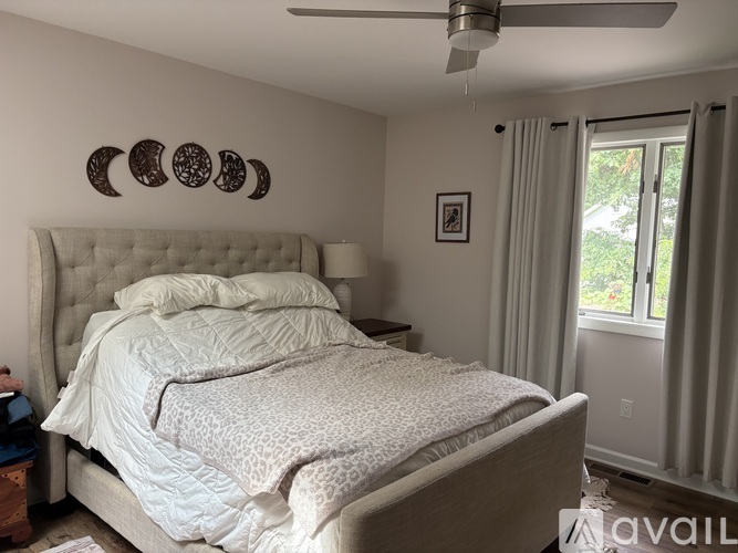A bedroom with a large bed and a ceiling fan.