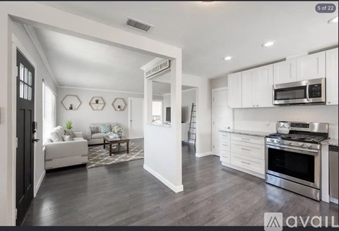 A modern kitchen with white cabinets and stainless steel appliances.