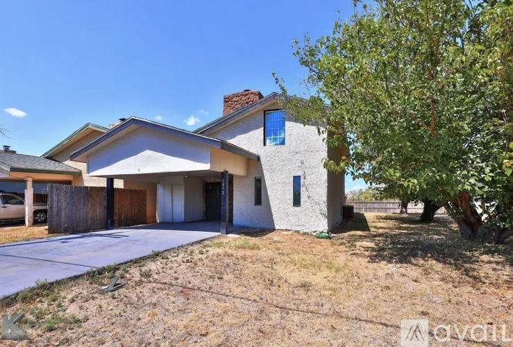 A house with a blue window and a tree in front.