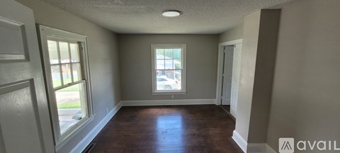 A room with a window and a door is available for rent.