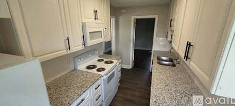 A kitchen with white cabinets and a granite countertop.
