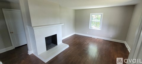 A living room with a fireplace and a window.