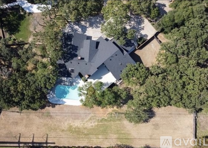 A house with a pool surrounded by trees.