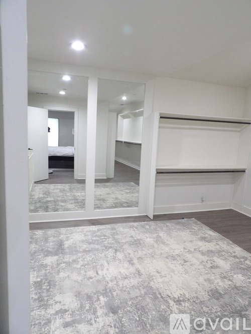 A spacious room with a grey carpet and white walls.