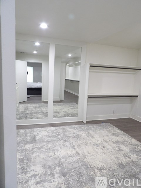 A spacious room with a grey carpet and white walls.