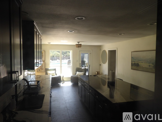 A modern kitchen with black cabinets and a large island.