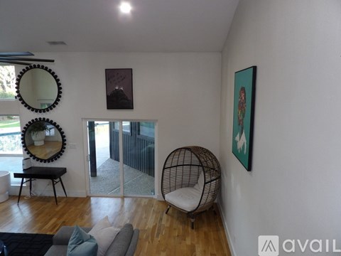 A living room with a grey couch and a hanging chair.