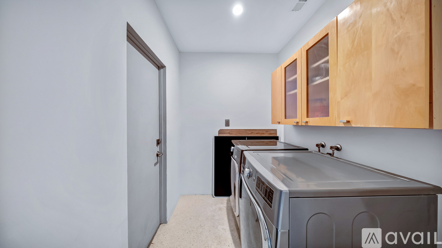 A kitchen with wooden cabinets and a stainless steel dishwasher.