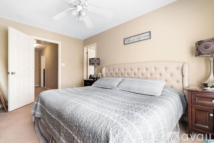 A bedroom with a large bed and a ceiling fan.