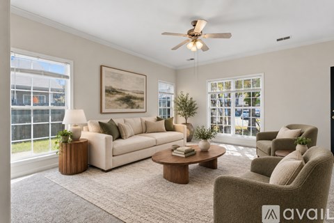 A living room with a large couch, a coffee table, and a painting on the wall.