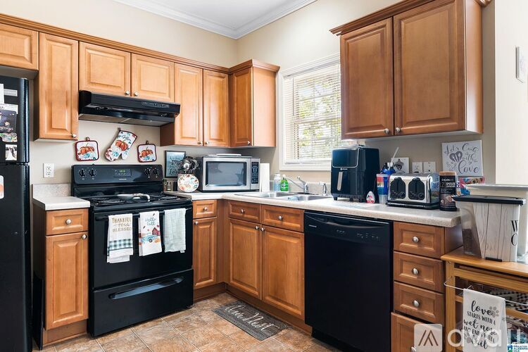 A kitchen with wooden cabinets and black appliances.