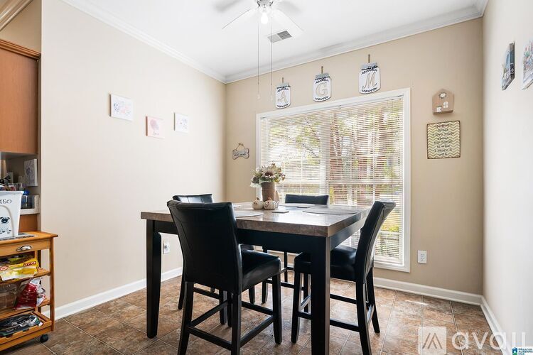 A dining room with a table and chairs.