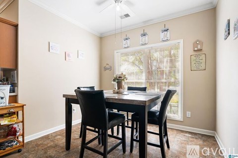 A dining room with a table and chairs.