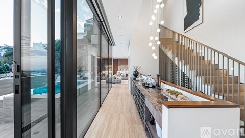 A modern kitchen with a glass wall and a staircase.