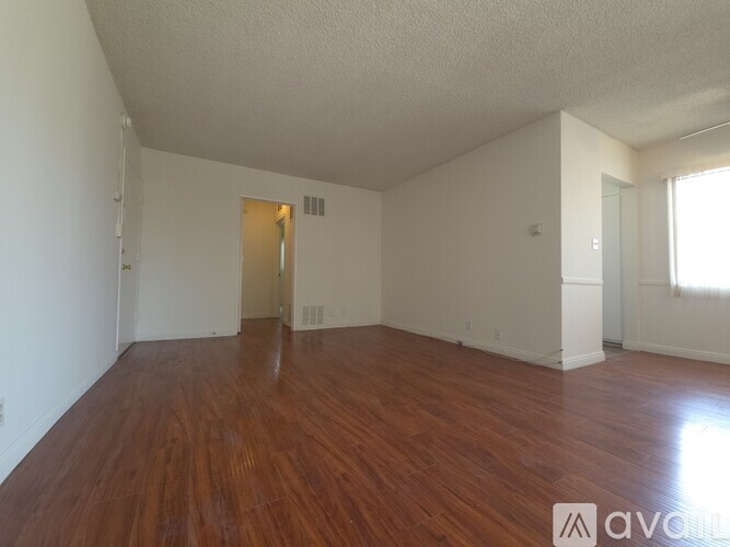 A room with wooden flooring and a ceiling fan.