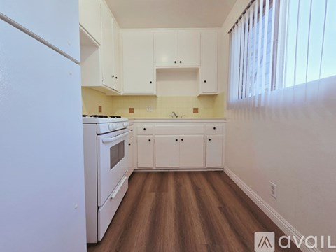 A kitchen with white appliances and cabinets.