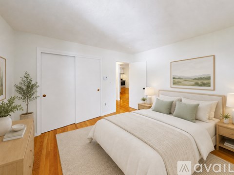 A bedroom with a large bed and a painting on the wall.