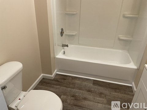A white toilet sits next to a bathtub in a bathroom.