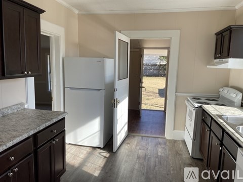 A kitchen with a white refrigerator and black cabinets.