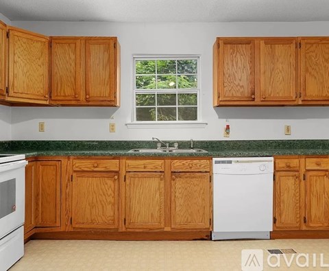 A kitchen with wooden cabinets and a white dishwasher.