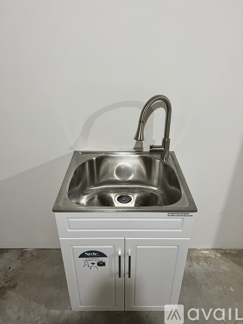 A kitchen sink with a faucet and a cabinet below it.